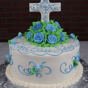 The RC-085B is a round white cake with blue and green icing, blue roses, and a large white cross featuring blue designs. "God Bless Sean" is written on top in blue script.