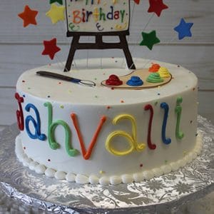 The CB-030 is a round white birthday cake with colorful icing, a paint palette, paintbrush, stars, and an easel topper that says "Happy 7th Birthday." Jahvalli is written in rainbow colors on the side.