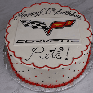 ST-015: Round white cake with red and black decorations, topped with a Corvette logo and "Happy 60th Birthday Pete!" in black icing, presented on a silver cake board.