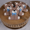 The CE-004d baby shower features bear-shaped cookies with brown icing, white paws, and blue bows arranged on a round wooden board over a light marble surface.