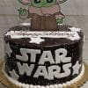 The CB-007D is a chocolate cake with white stars, STAR WARS lettering, a Baby Yoda cutout on top, and "Happy Birthday" written in white icing.