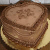 The BD-023B Heart shape one size cake features decorative frosting, piped borders, and "22" written on top. It is presented on a gold-colored base with a wooden background.