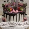 The BD-024N PinkWhitney is a white and chocolate drip cake with pink frosting, strawberries, mini Pink Whitney bottles, chocolate hearts, a silver 21 topper, and a “Happy Birthday Amber & Alisha” sign.