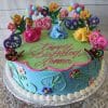 A colorful birthday cake named SC-020 Three Disney Princess, decorated with three princess figurines, flowers, butterflies, blue and green icing, and pink "Happy Birthday Donna" writing.