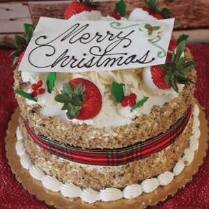 Round carrot cake with cream cheese filling, decorated with festive Christmas accents. Features a white chocolate "Merry Christmas" plaque, plaid ribbon wrap, and presented on a gold board. Product Name: CH-003.