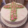 RC-032 is a round white cake featuring a cross of pink and green icing roses. "God Bless" and "Rose Maria" are written in pink icing, with the edges finished in white piped details.