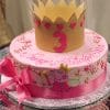 CB-009E is a pink birthday cake with a crown, pink hearts, a large number 3, a pink ribbon, and Peppa Pig as a fairy. "Happy Birthday Sara" is written in pink script on the cake.