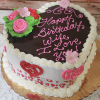Heart-shaped cake (VC-011) with chocolate glaze, pink and white icing, floral roses and hearts, and "Happy Birthday Wife, I Love You!" written on top.