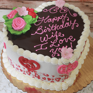 Heart-shaped cake (VC-011) with chocolate glaze, pink and white icing, floral roses and hearts, and "Happy Birthday Wife, I Love You!" written on top.