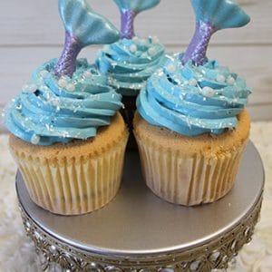 Three CC-026A cupcakes—gold with chocolate filling—decorated and displayed on an ornate silver cake stand.