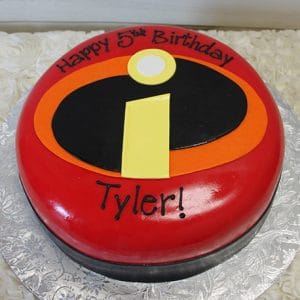 CB-006F is a round, red cake featuring The Incredibles logo and "Happy 5th Birthday Tyler!" in black icing, presented on a silver floral-patterned board.