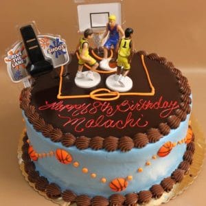 SC-051 Basketball: Round birthday cake with a basketball court design, three basketball player figurines, orange basketball details, and "Happy 8th Birthday Malachi" written in red icing on top.
