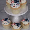 Golden cupcakes topped with football decorations, red white and blue sprinkles, and New England Patriots logo toppers